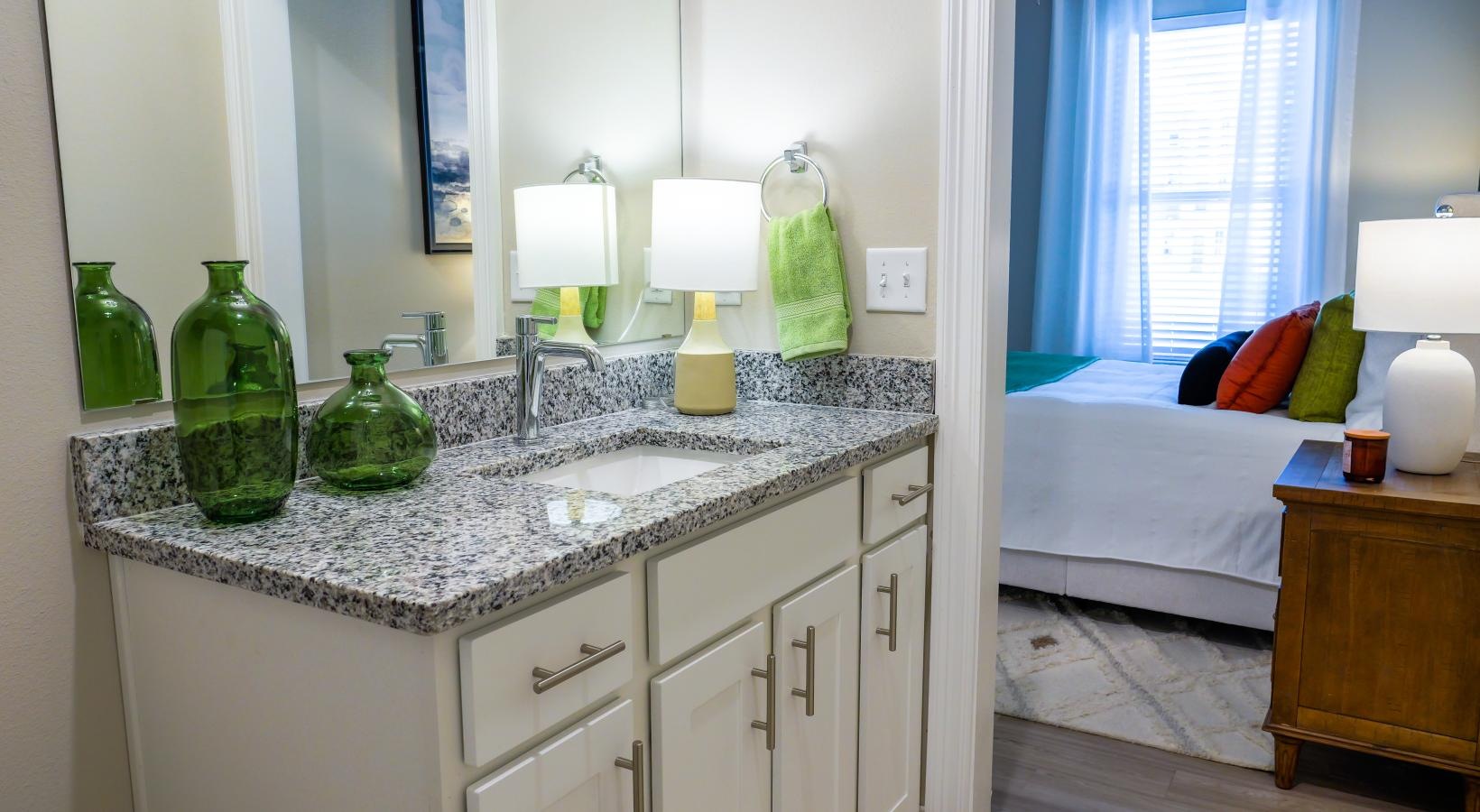 Generous bedroom offerings to fit every family a bathroom with a sink and a bed  in the background