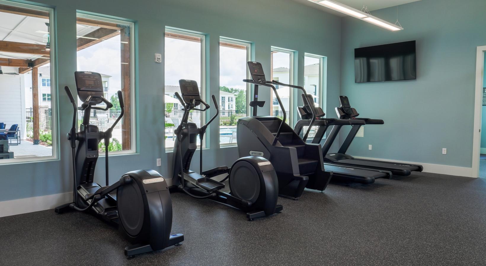 Cutting-edge amenities at your fingertips a gym with exercise equipment and windows