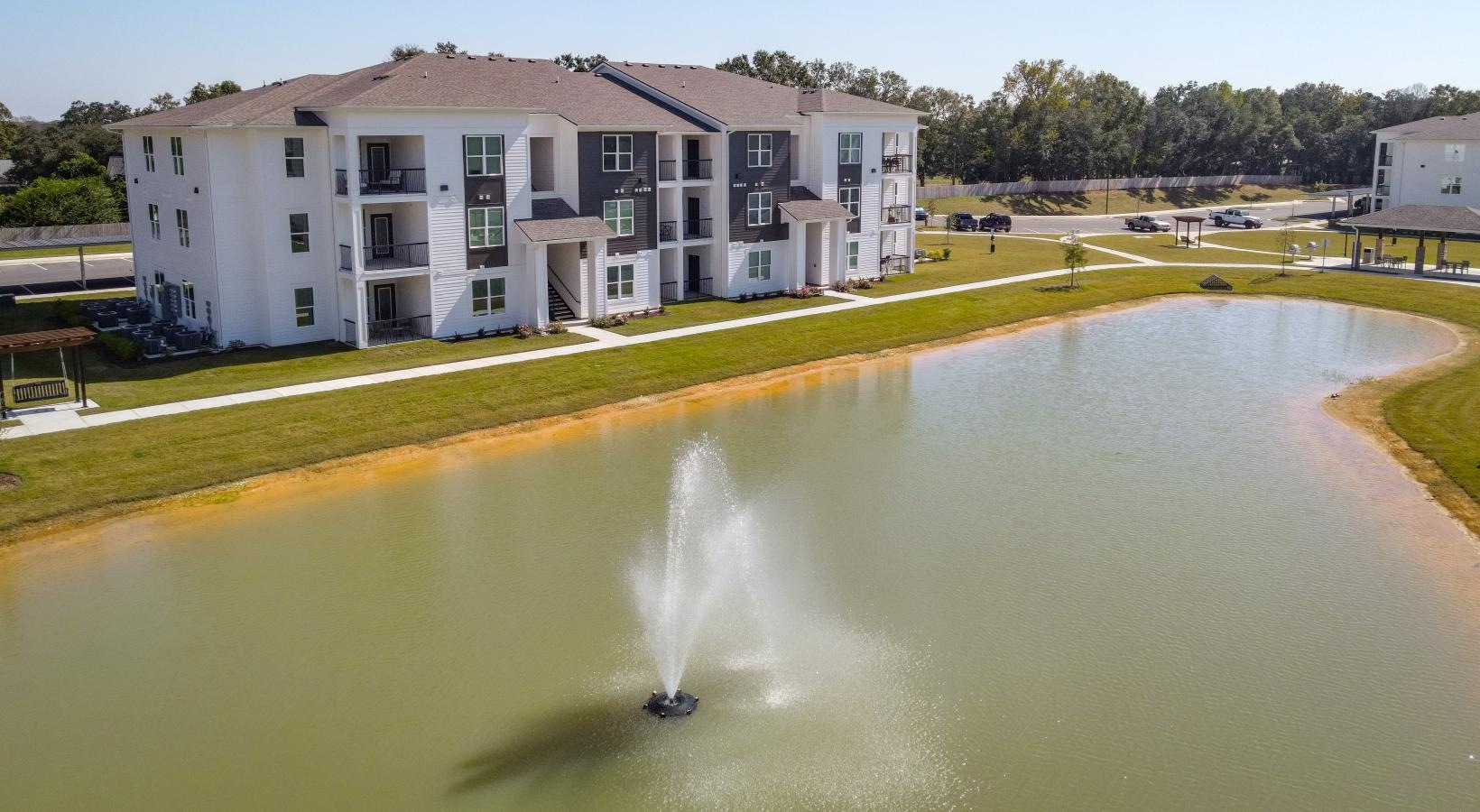 The essence of exceptional living a building with a fountain in a pond in the front