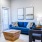 a living room with a blue couch a coffee tables chairs and a large window