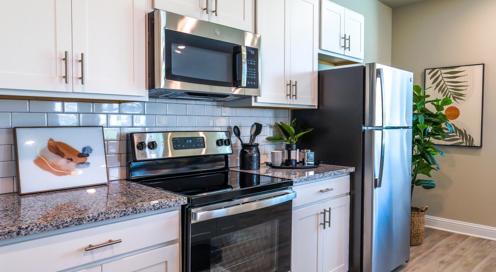 Beautiful kitchens with designer finishes a kitchen with white cabinets a stovetop a fridge