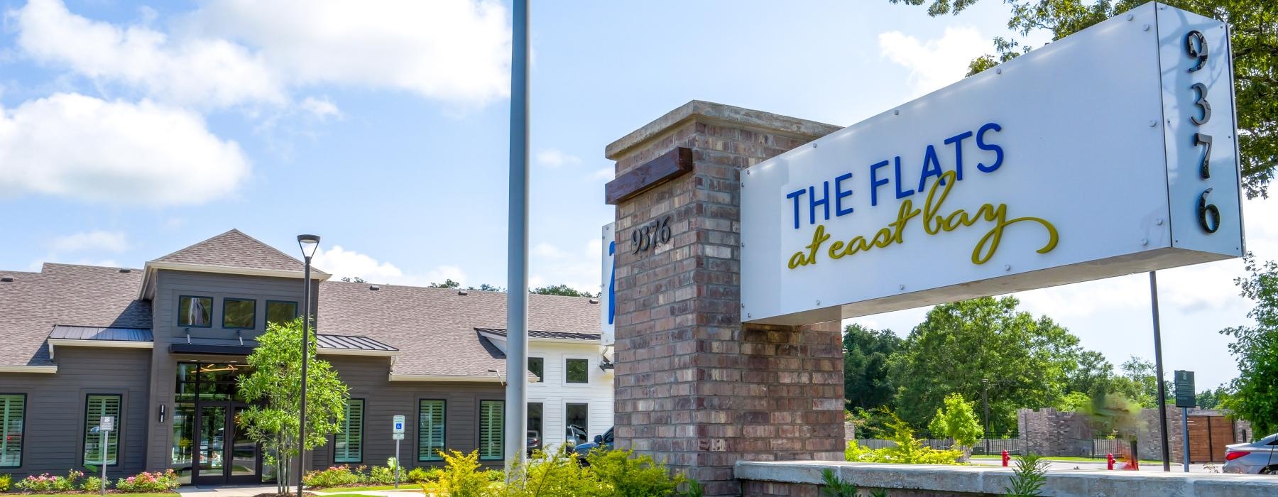 a sign in front of a building that reads the flats at east bay
