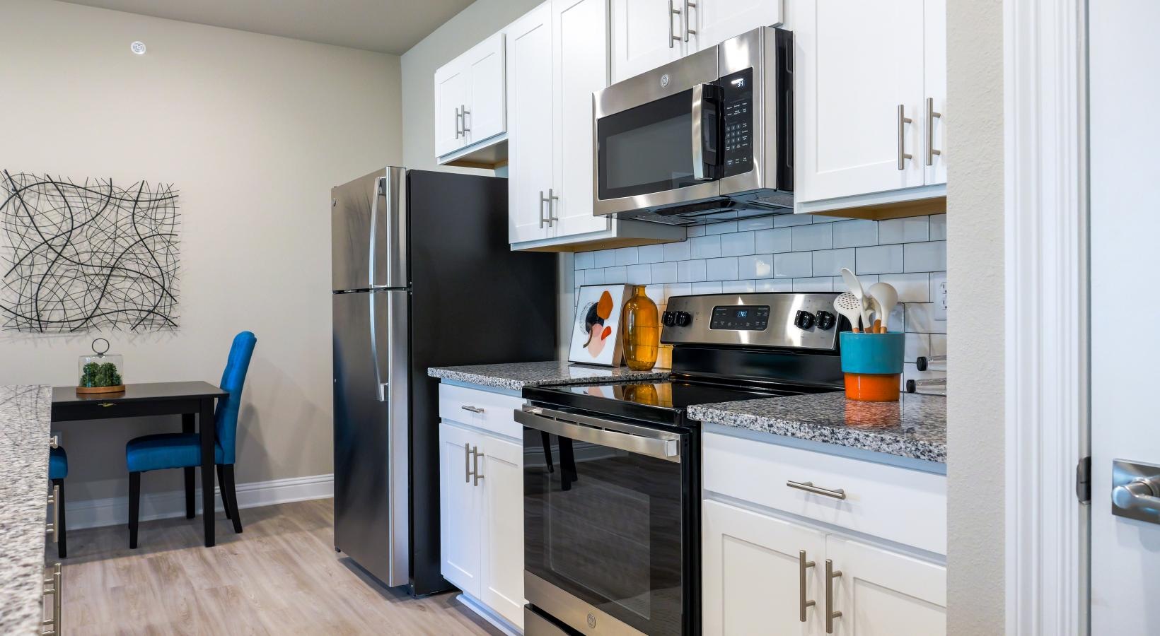 Spacious kitchens with thoughtful details a kitchen with white cabinets a fridge and a stovetop