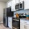 a kitchen with white cabinets a fridge and a stovetop