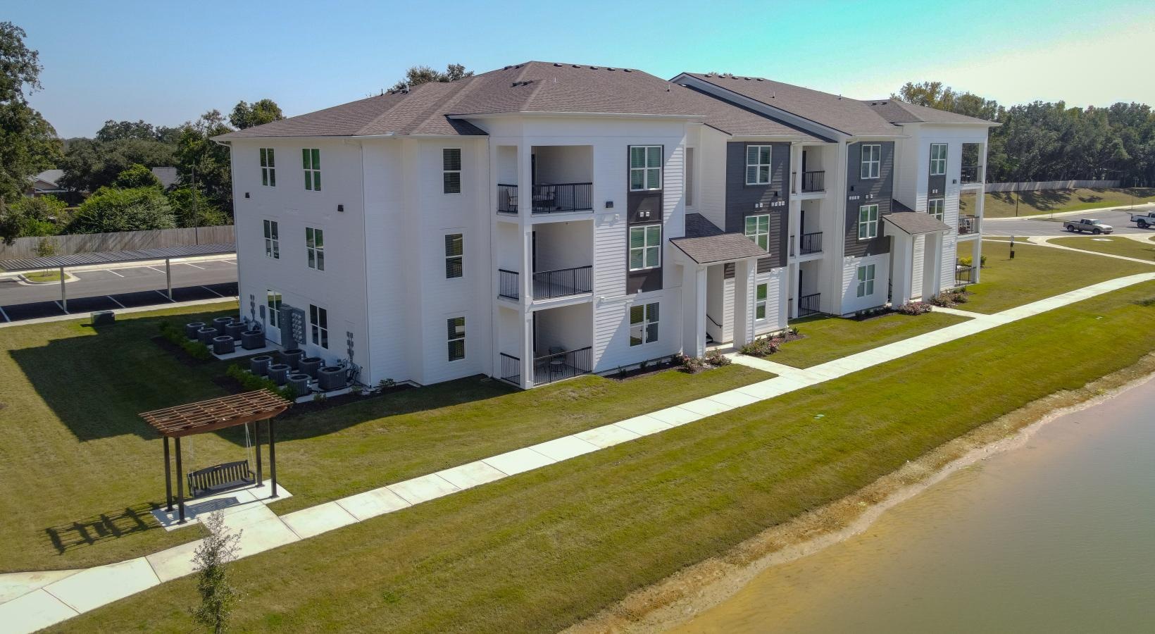 Find your perfect fit at The Flats at East Bay a large white building by a body of water