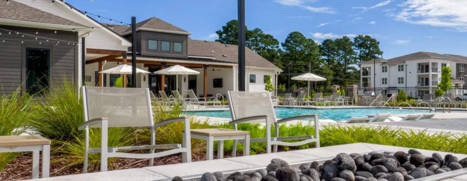 a pool with a table and chairs and a firepit