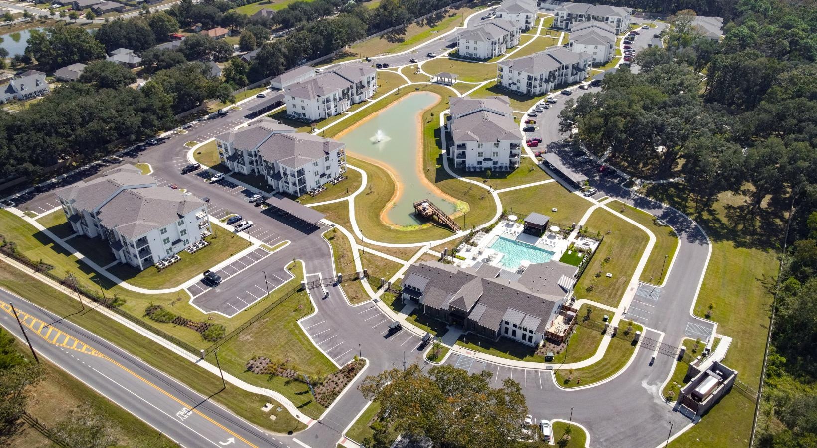 Find your perfect fit at The Flats at East Bay aerial view of a large building and a pond