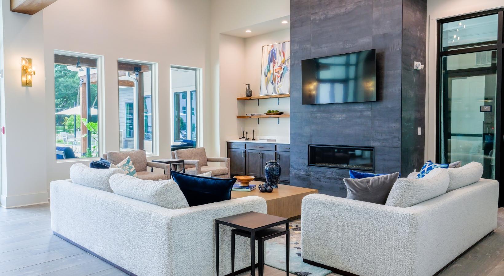 Settle into comfort at The Flats at East Bay a lounge room with a fireplace couches and a tv