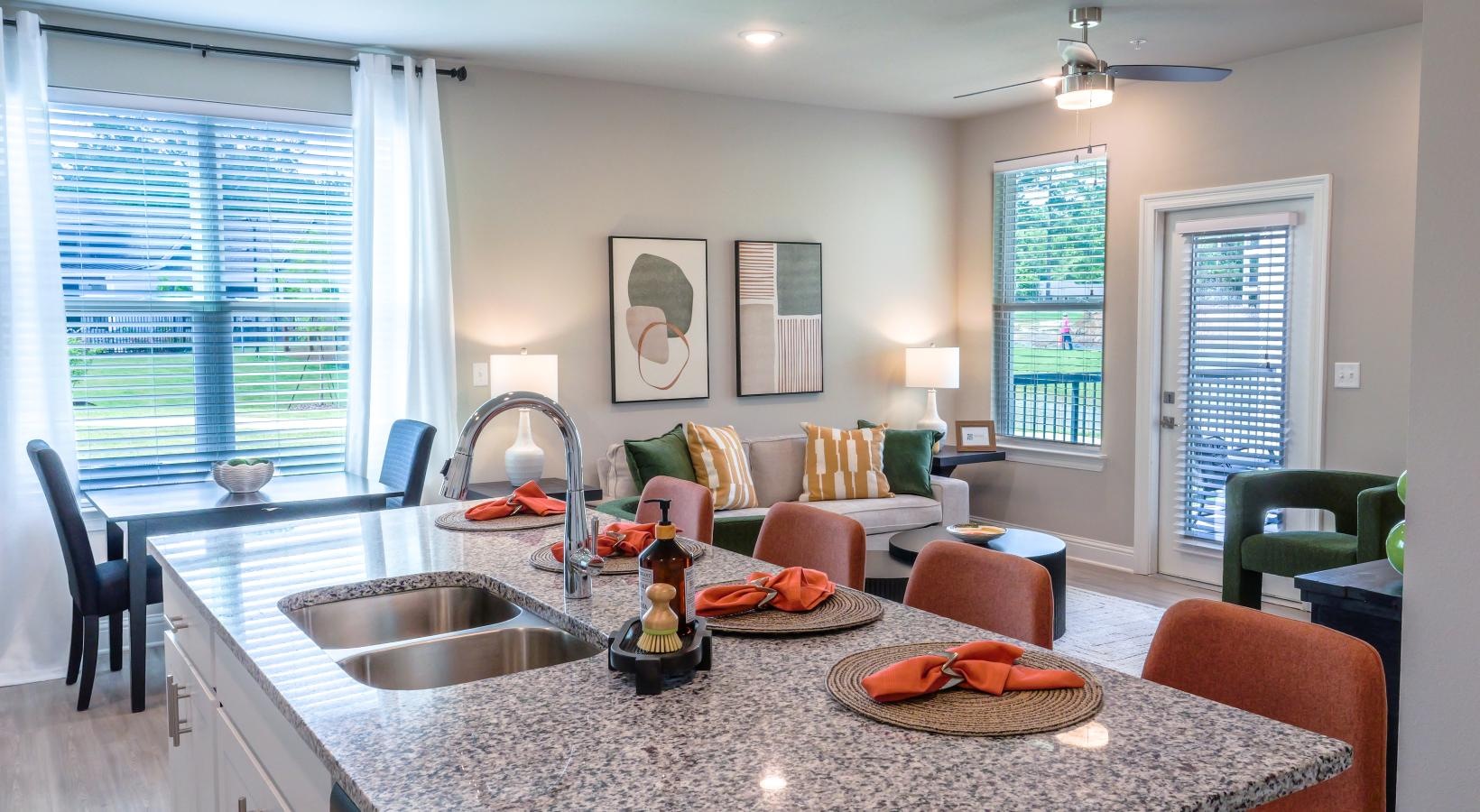 Spacious kitchens with thoughtful details a kitchen island with chairs and with a living room behind it